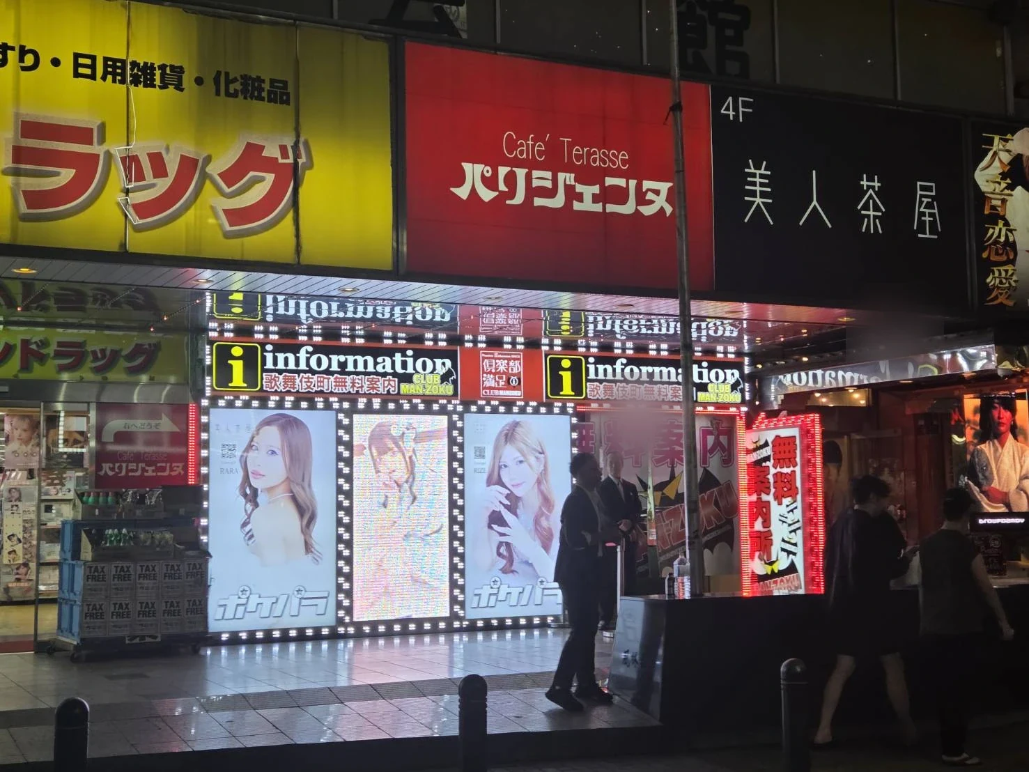 Free information center sign glowing down a side street in Kabukicho at night