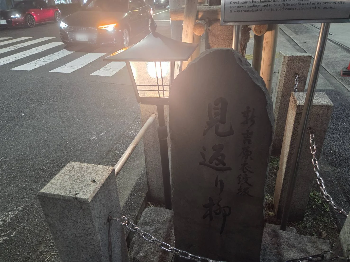 The Mikaeri-yanagi willow and its stone marker at the entrance to the former Yoshiwara quarter at night